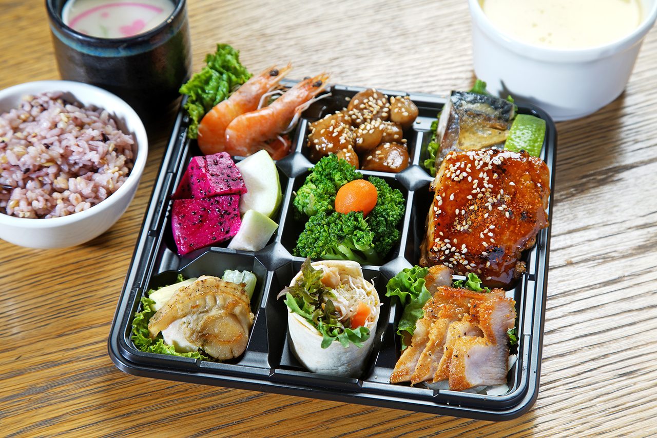 九宮格會議餐盒，黑色分格餐盒內盛裝燒肉、炸物、時蔬與水果，旁邊搭配一碗紫米飯