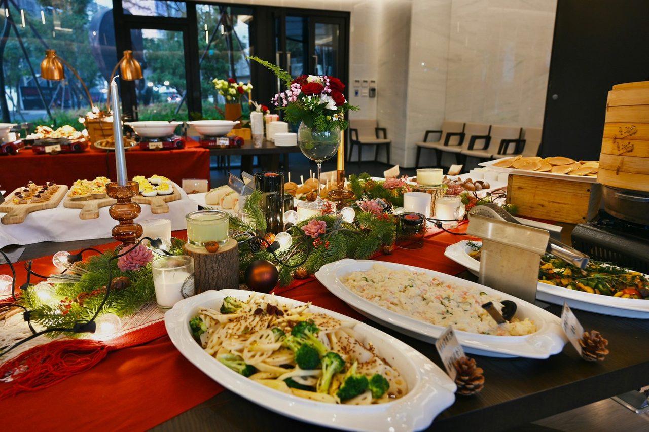 餐檯細節：桌布、桌花與器皿都算在服務裡。白瓷長盤上的義大利麵與周圍小點構成完整餐檯。